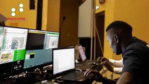 Puzzlepie Sambia at VCA. A video technician at his workstation with computers.